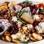 festive holiday cheese board with assorted cheese and charcuterie.