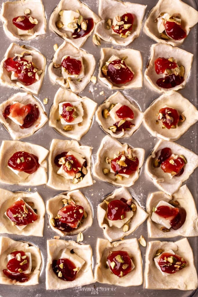 puff pastry in muffin tins with brie, jam and pistachio cups.