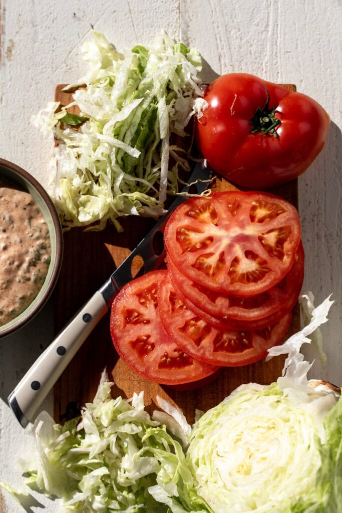 ingredients to make crispy fried oyster mushroom po boy on cutting board.