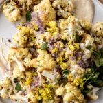 Roasted Cauliflower with Tahini recipe topped with pepperoncini and shallots.