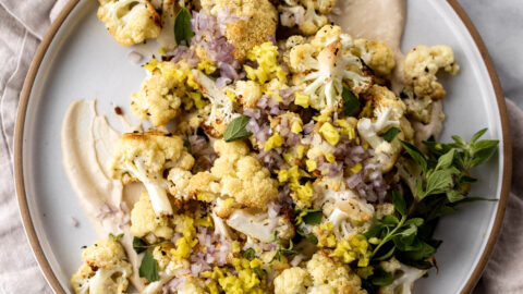 Roasted Cauliflower with Tahini recipe topped with pepperoncini and shallots.