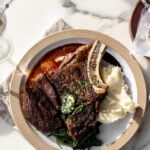 Seared steak with red wine reduction and garlic compound butter over mashed potatoes.