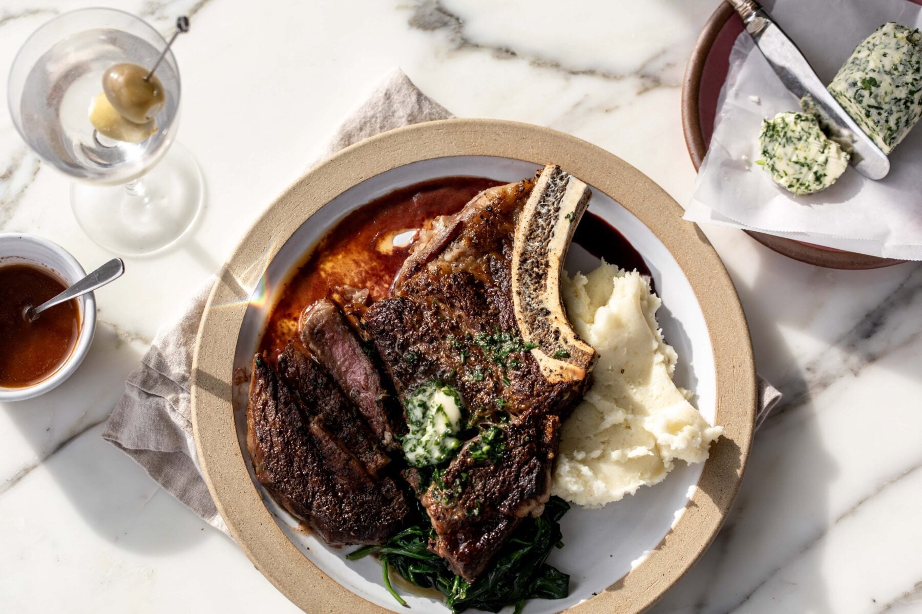 Seared steak with red wine reduction and garlic compound butter over mashed potatoes.