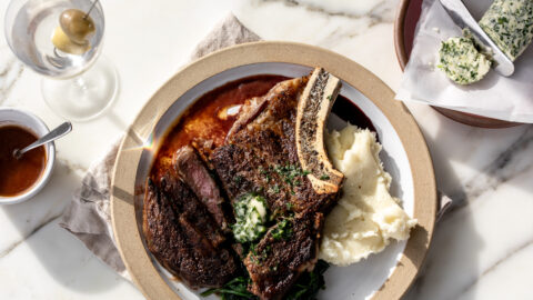 Seared steak with red wine reduction and garlic compound butter over mashed potatoes.