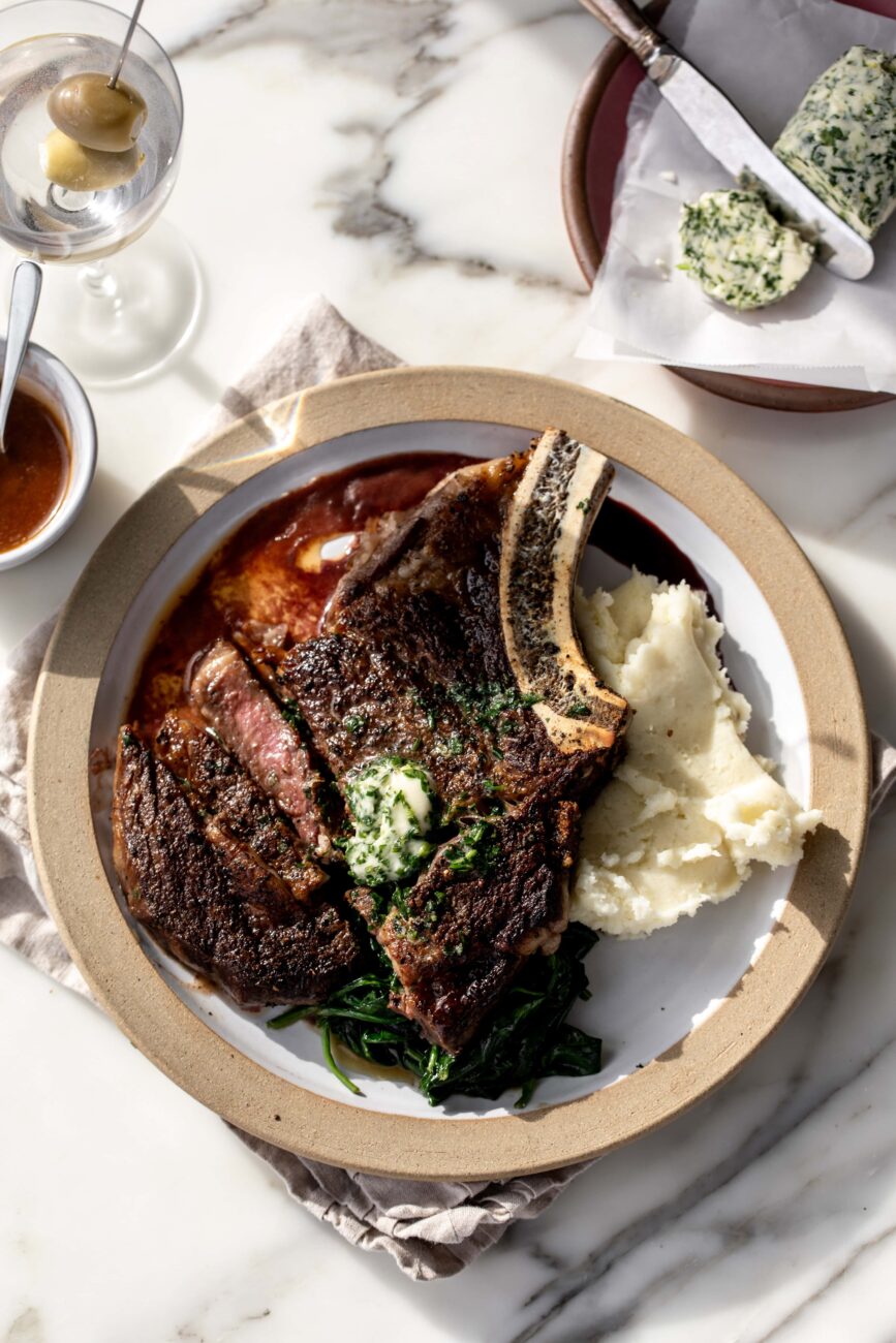 Seared steak with red wine reduction and garlic compound butter over mashed potatoes.