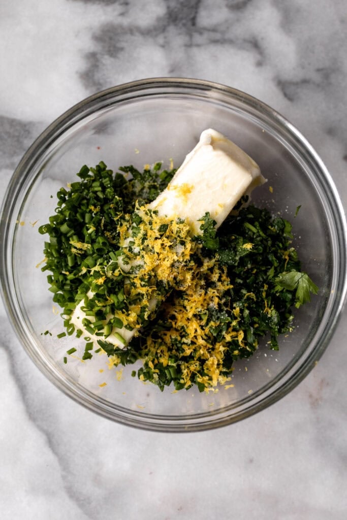 garlic and herb compound butter in glass mixing bowl.