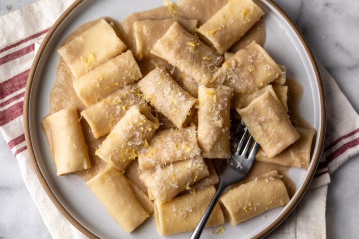 Simple creamy white bean and lemon pasta made with Paccheri noodles on plate.