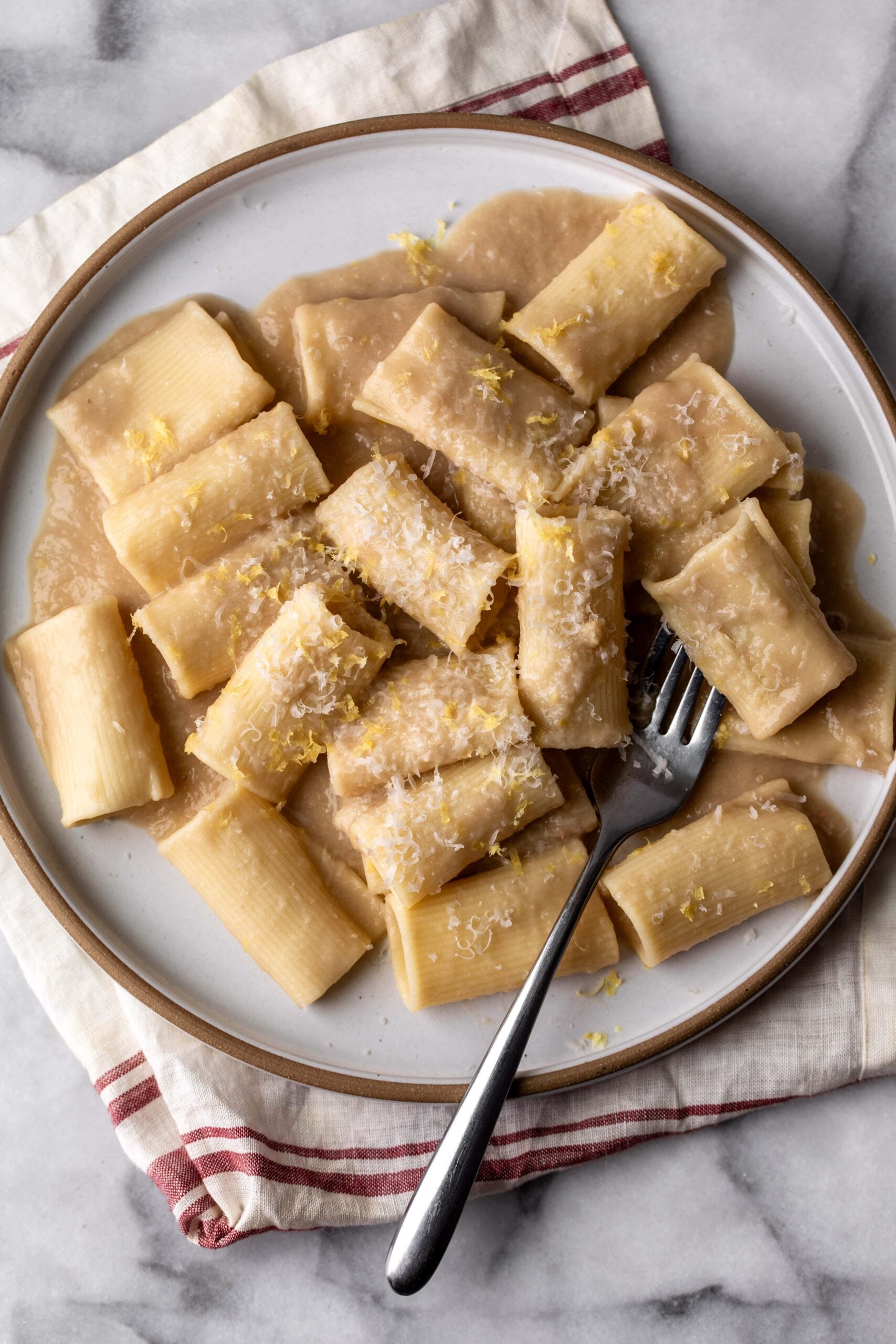 Simple creamy white bean and lemon pasta garnished with parmesan cheese and lemon zest.