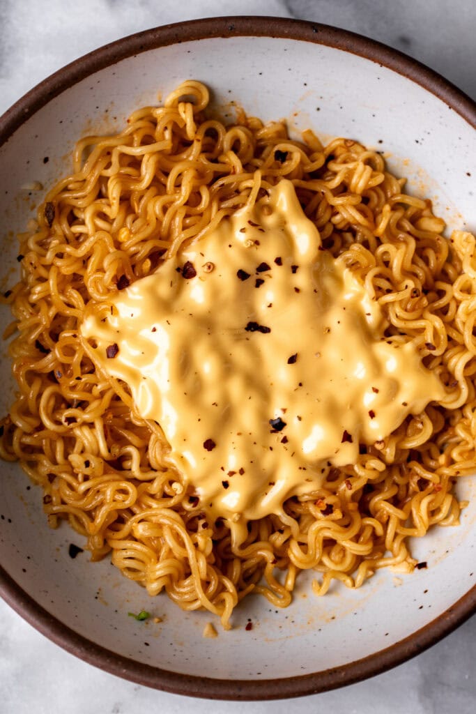 sauceless ramen topped with american cheese slice and red pepper.