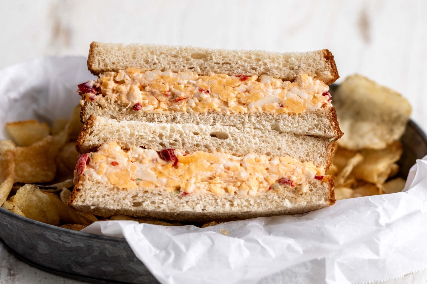 Southern pimento cheese sandwich on white bread cut in half.