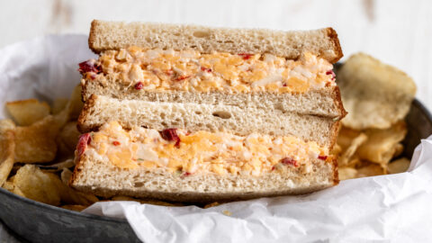 Southern pimento cheese sandwich on white bread cut in half.