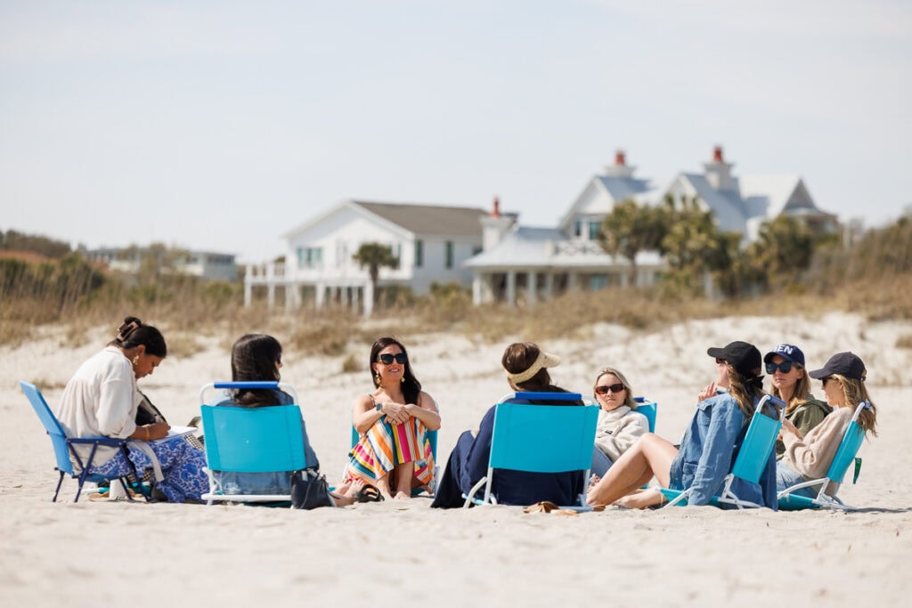 women sitting on beach in lounge chairs charleston, south carolina.