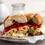 grilled artichoke sandwich with provolone cheese and red peppers on garlic bread.