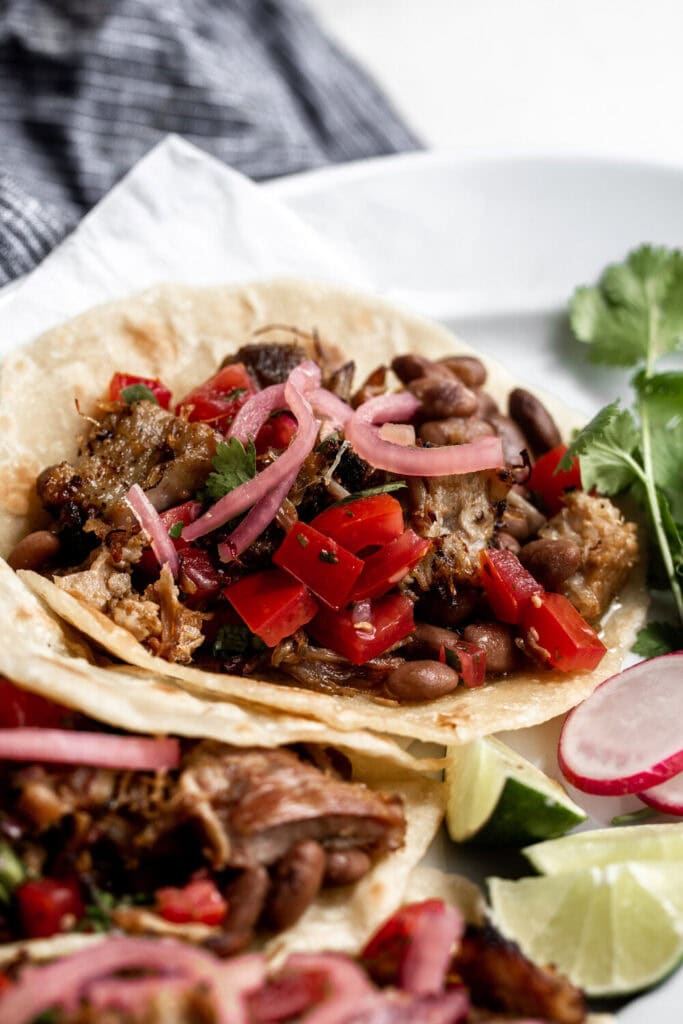 homemade carnitas tacos with pickled red onion and pico de gallo.