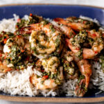 chimichurri shrimp over coconut rice on blue stoneware plate.