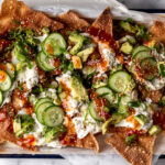 crab rangoon wonton nachos with cream cheese and sweet chili sauce on enamel tray.