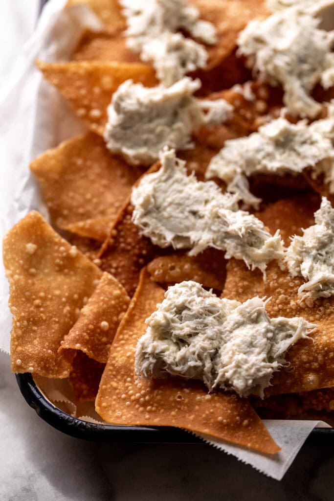 crab rangoon mixture spread on crispy wonton nachos.