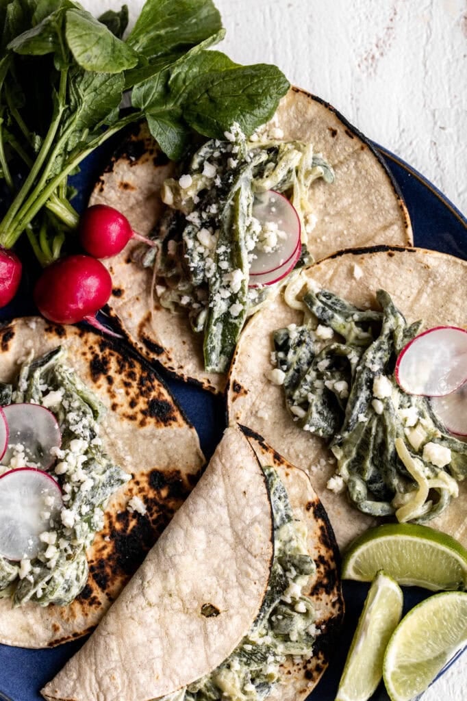 creamy poblano tacos on charred corn tortillas and radish slices,