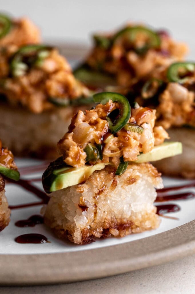fried crispy rice with spicy shrimp salad topped with jalapeño and avocado slice.