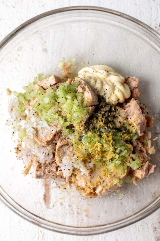 lemony tuna salad ingredients in glass bowl to be mixed. 