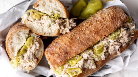 lemony tuna salad sandwich on baguette with pepperoncini.