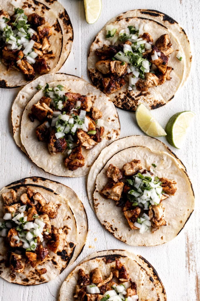 mexican chicken street tacos on small corn tortillas topped with onion salsa.