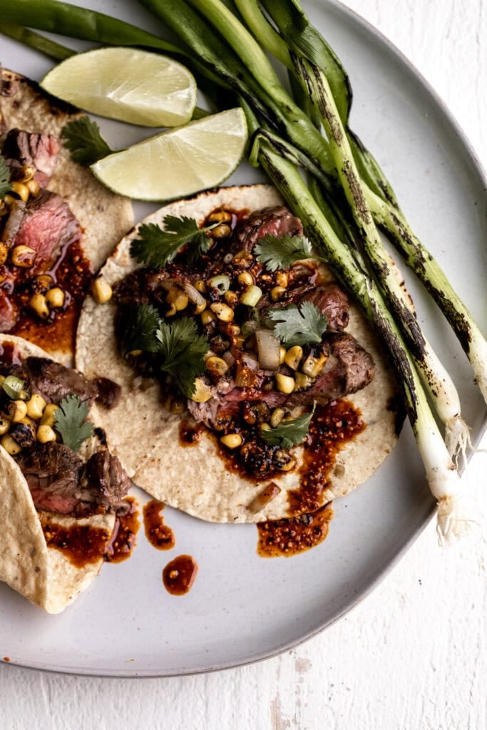 seared steak tacos with salsa macha, charred corn and green onion.