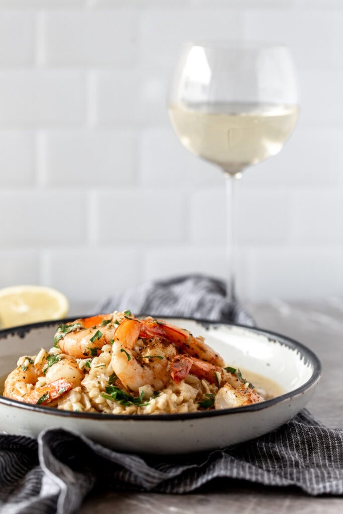 shrimp scampi risotto with glass of white wine.