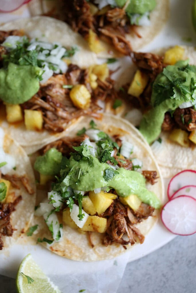 braised al pastor pork tacos with avocado-tomatillo salsa.