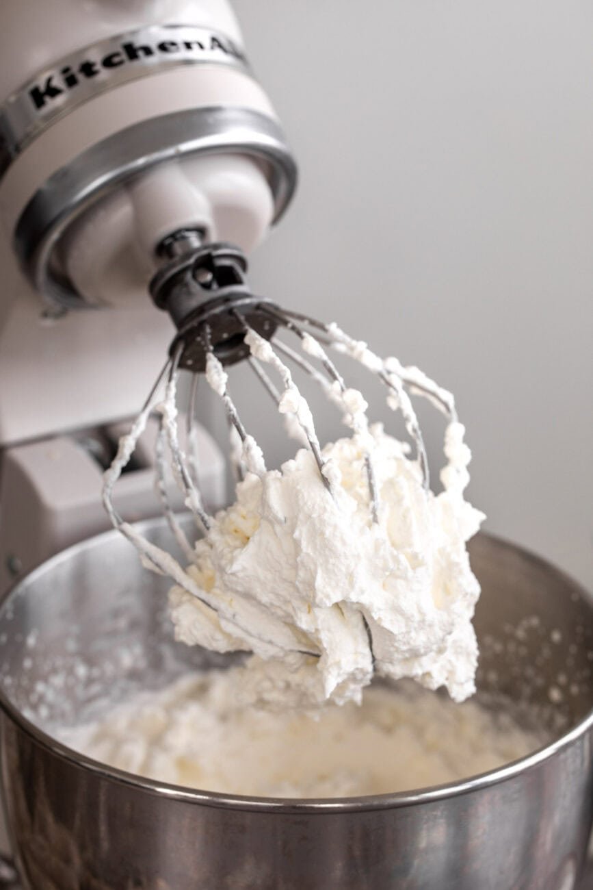 whipped cream stiff peaks on mixer whisk.