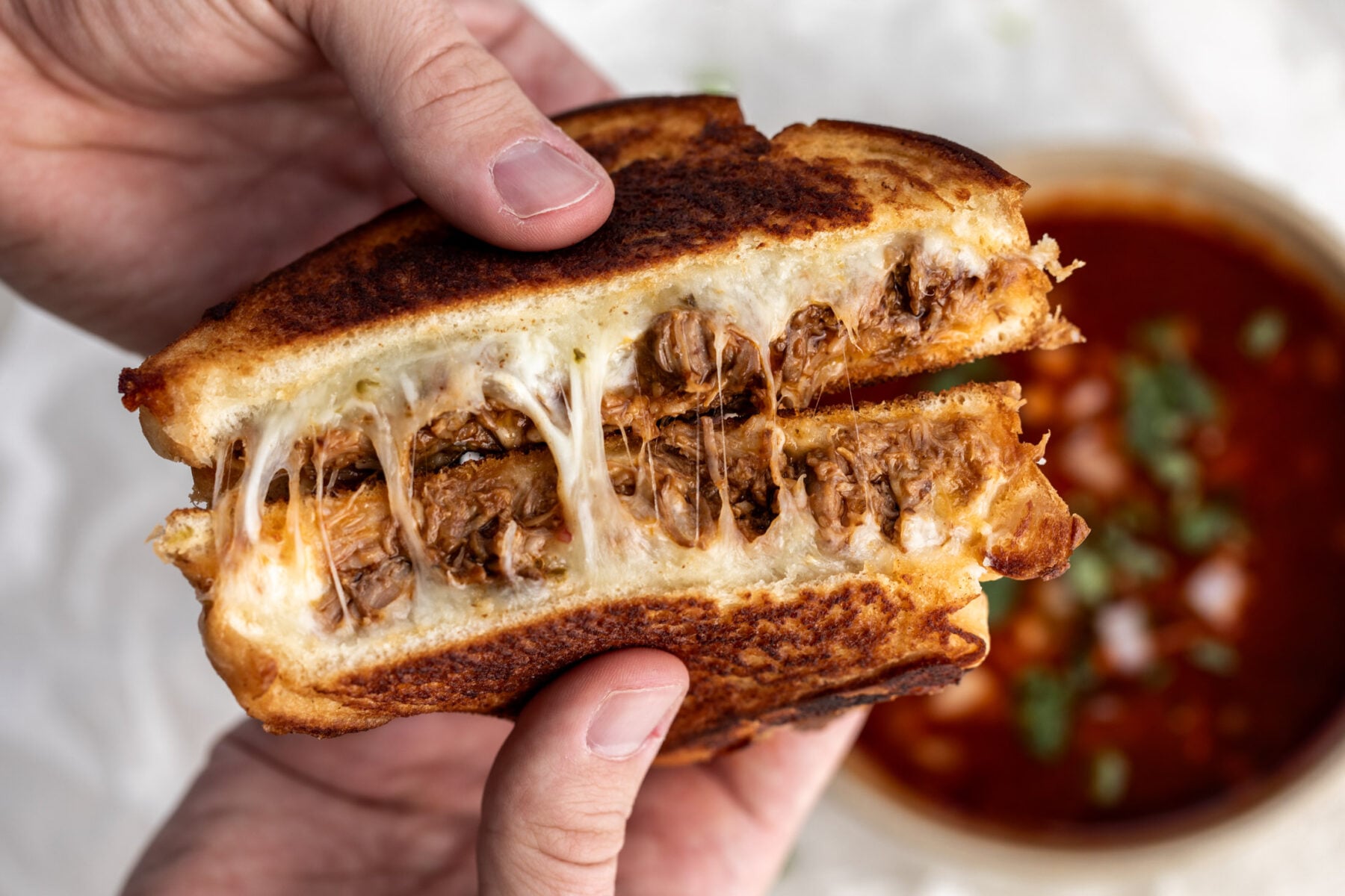 birria grilled cheese pulled open with consommé for dipping.