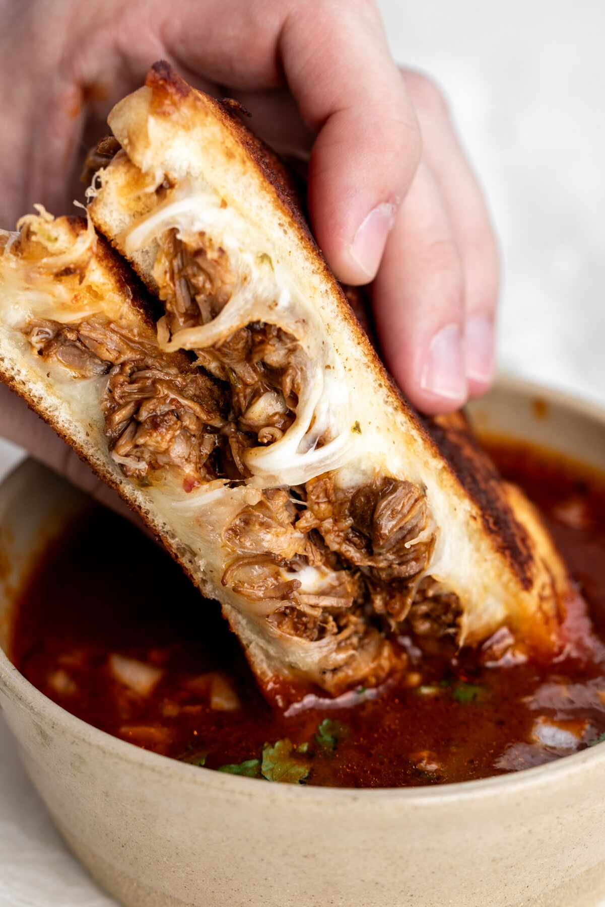 birria grilled cheese dipped in red consommé broth.