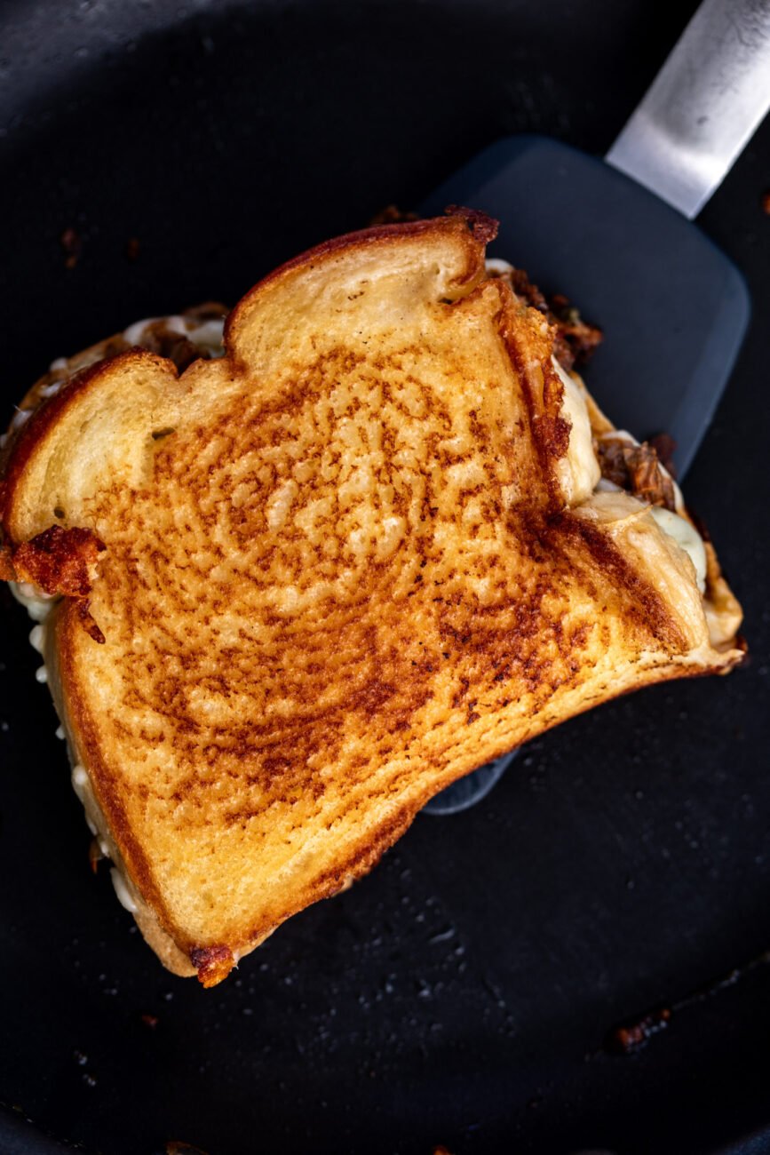 golden brown grilled cheese sandwich in pan.