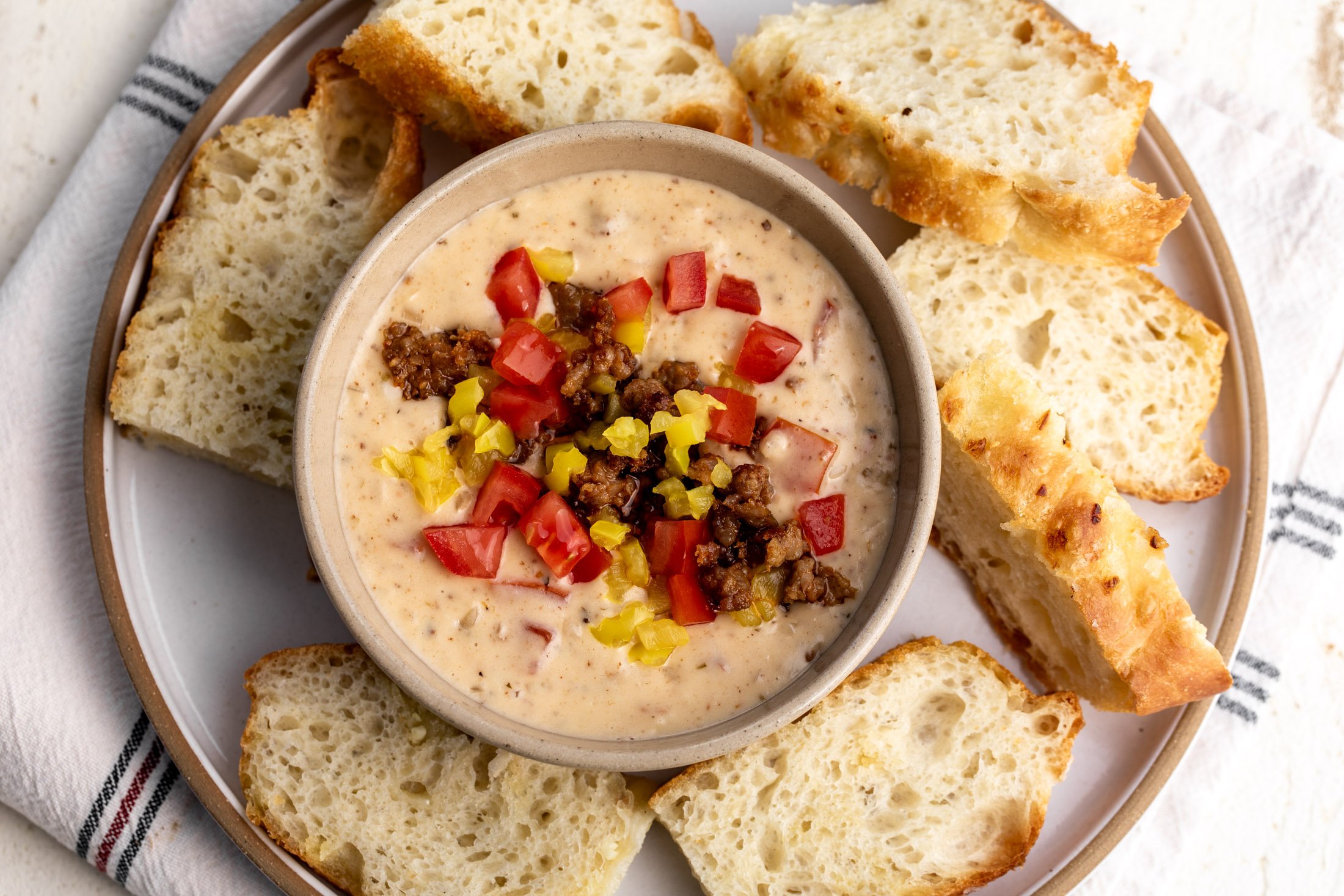 italian queso with sausage topped with tomaotes and peppers.