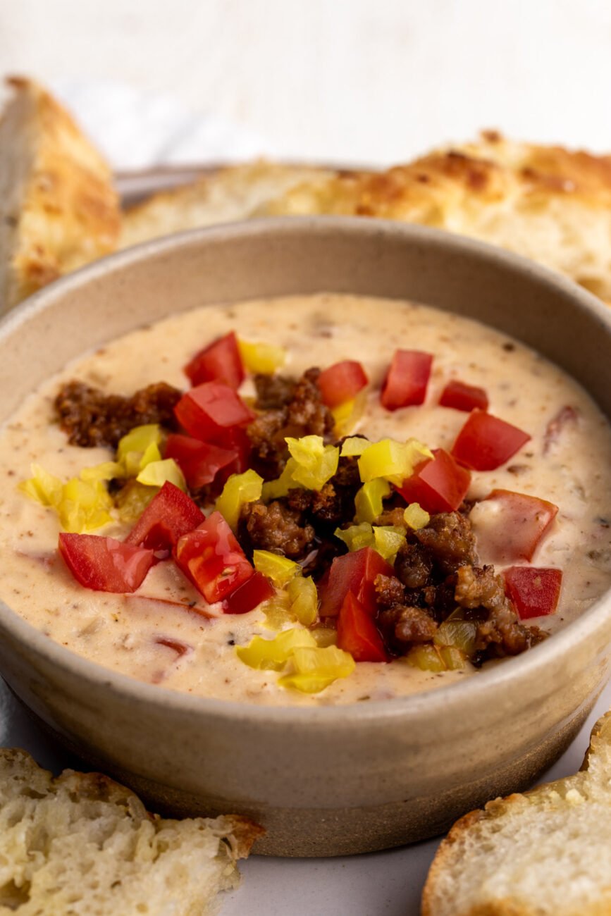 italian queso with sausage topped with tomaotes and peppers with foccacia.
