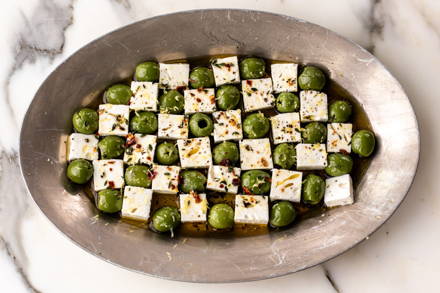 marinated green castelvetrano olives and feta cheese in checkerboard pattern.