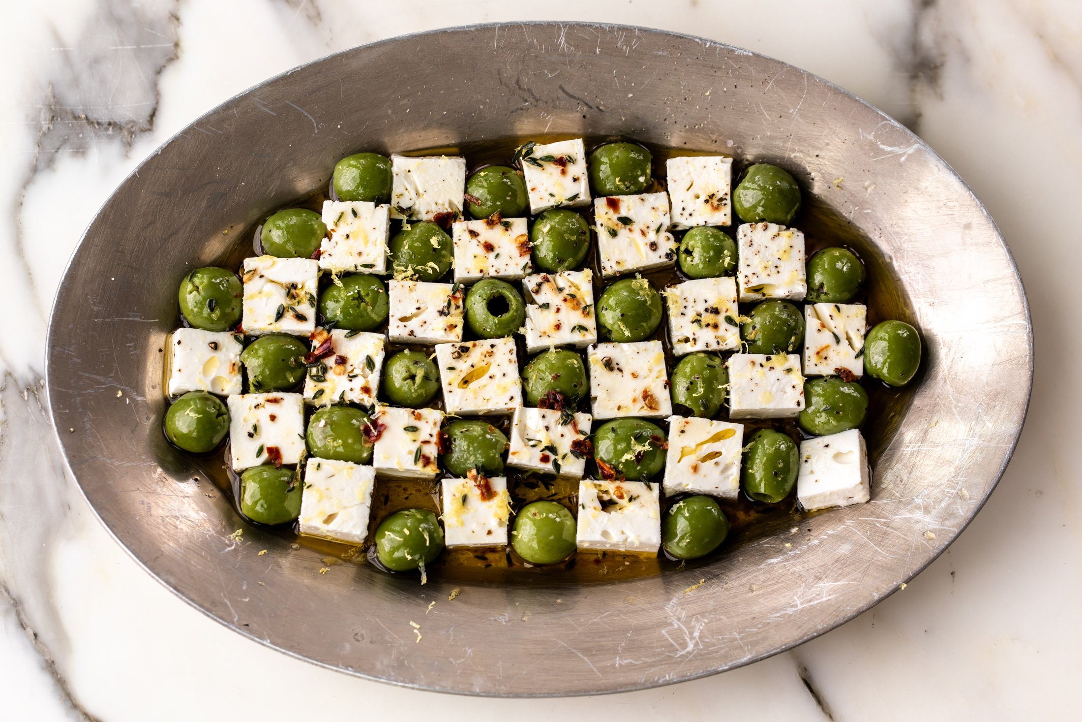 marinated green castelvetrano olives and feta cheese in checkerboard pattern.