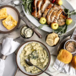 garlic herb butter, miso scallion butter and brown butter sage butter in dishes on thanksgiving table.