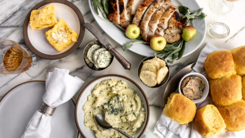 garlic herb butter, miso scallion butter and brown butter sage butter in dishes on thanksgiving table.
