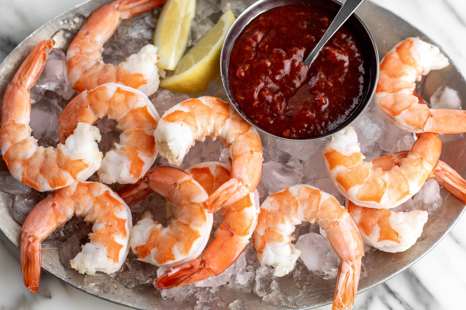 Shrimp Cocktail with Spicy Calabrian Chili Cocktail Sauce on platter with ice.