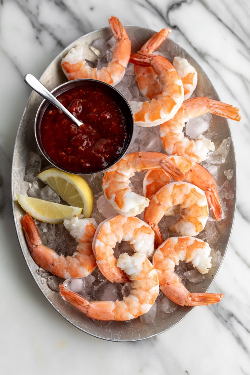 spicy calabrian chili shrimp cocktail on platter with ice.