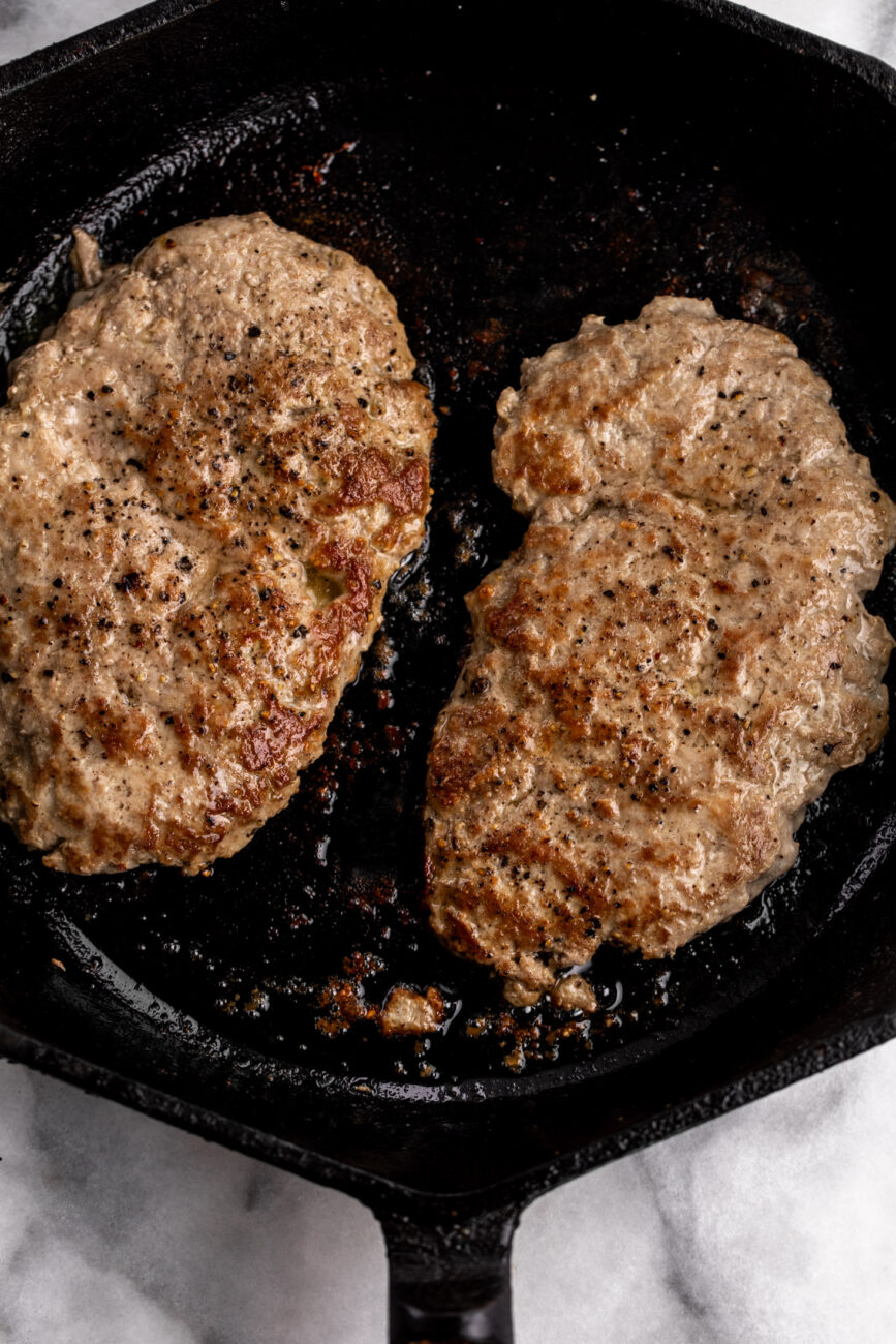 browned turkey patties in cast iron pans.