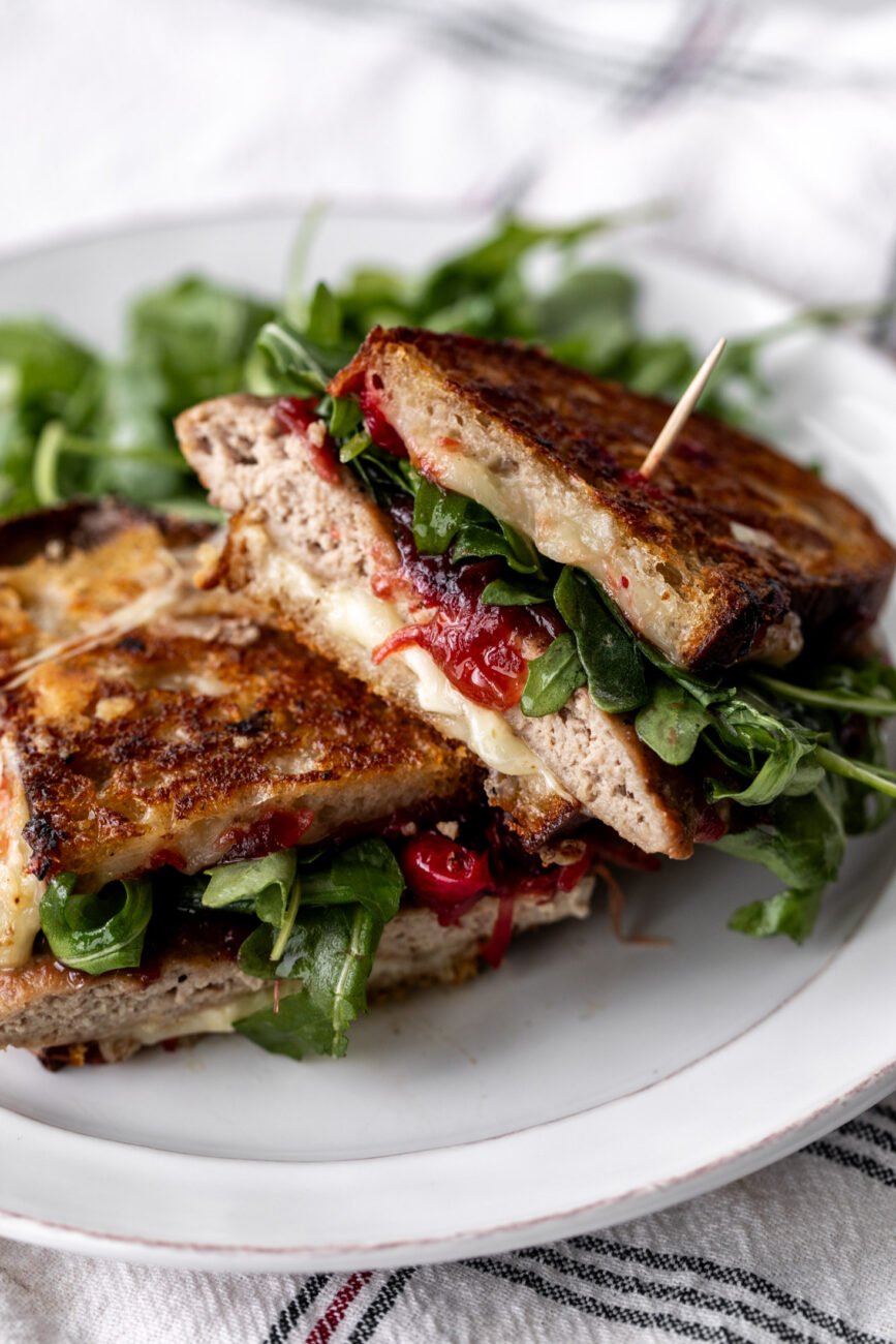 Thanksgiving turkey patty melt with cranberry onion jam on crisp bread.