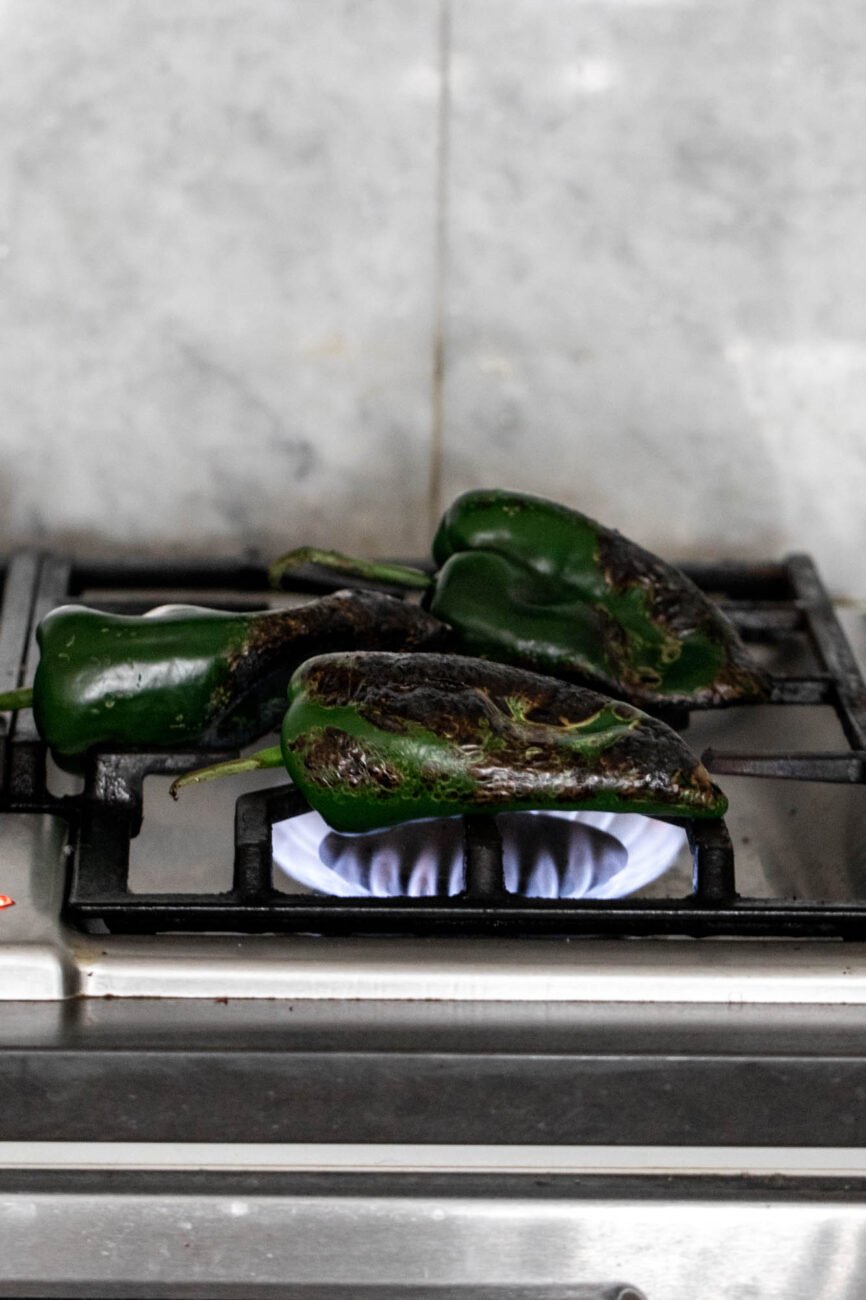 charred poblanos over gas flame.