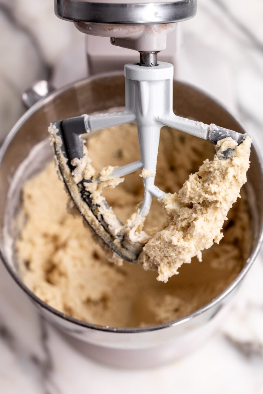 prepared cookie dough in stand mixer with paddle.