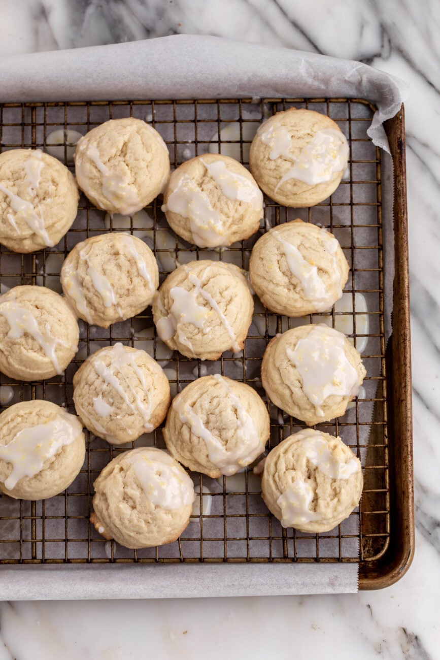 iced lemon cookies on parchment paper lined baking sheet.