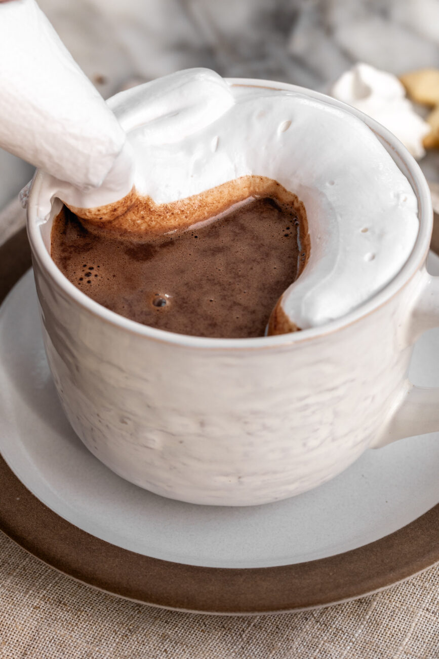 piped italian meringue over hot chocolate mug.