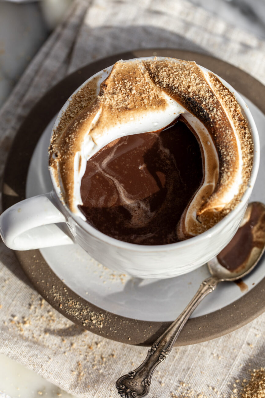 overhead hot chocolate in mug with piped and toasted italian meringue s\'mores. 