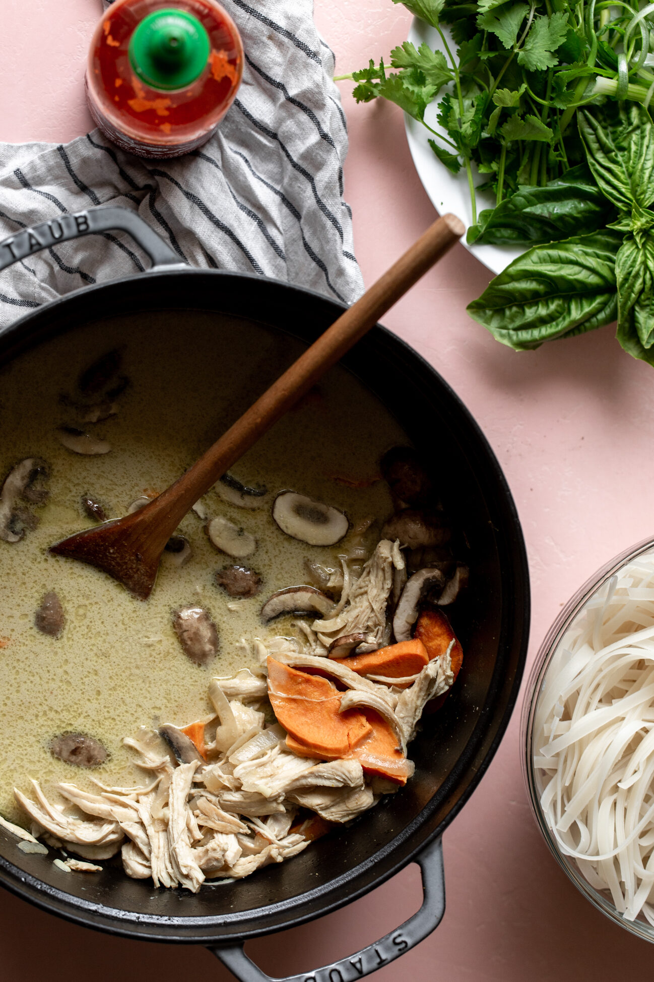 Green Curry Pho with Chicken with rice noodles garnished with herbs.