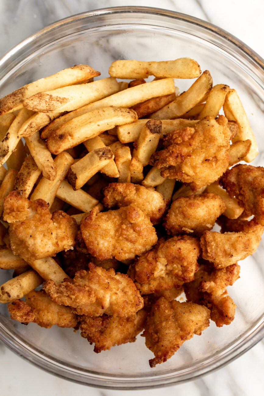 air fried chicken nuggets and french fries in a bowl.